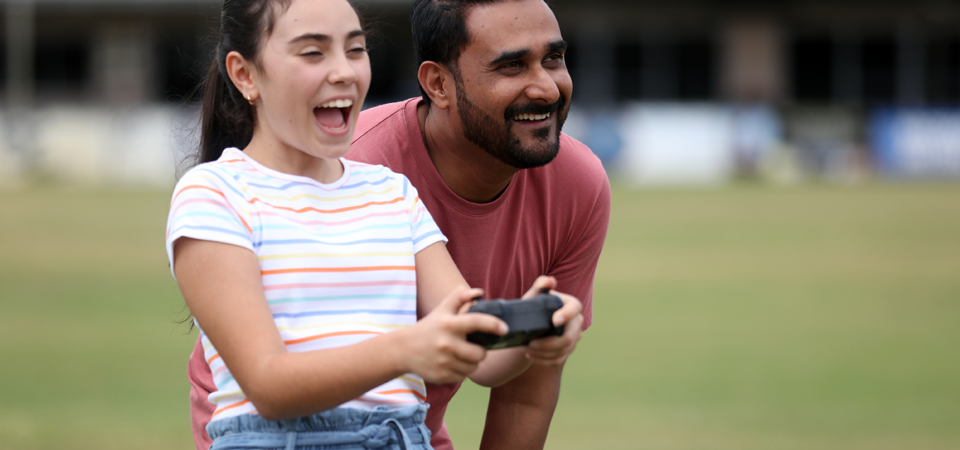 Drone being flown by child and adult.