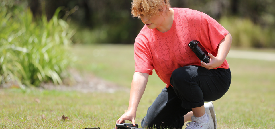 Drone being picked up by a person off the ground.