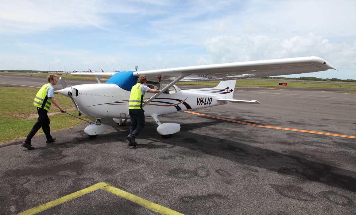Two pilots are pushing an aircraft