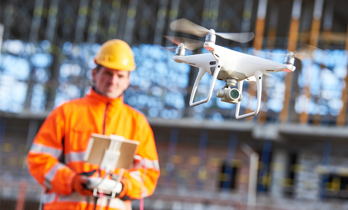 Construction worker remote piloting a drone