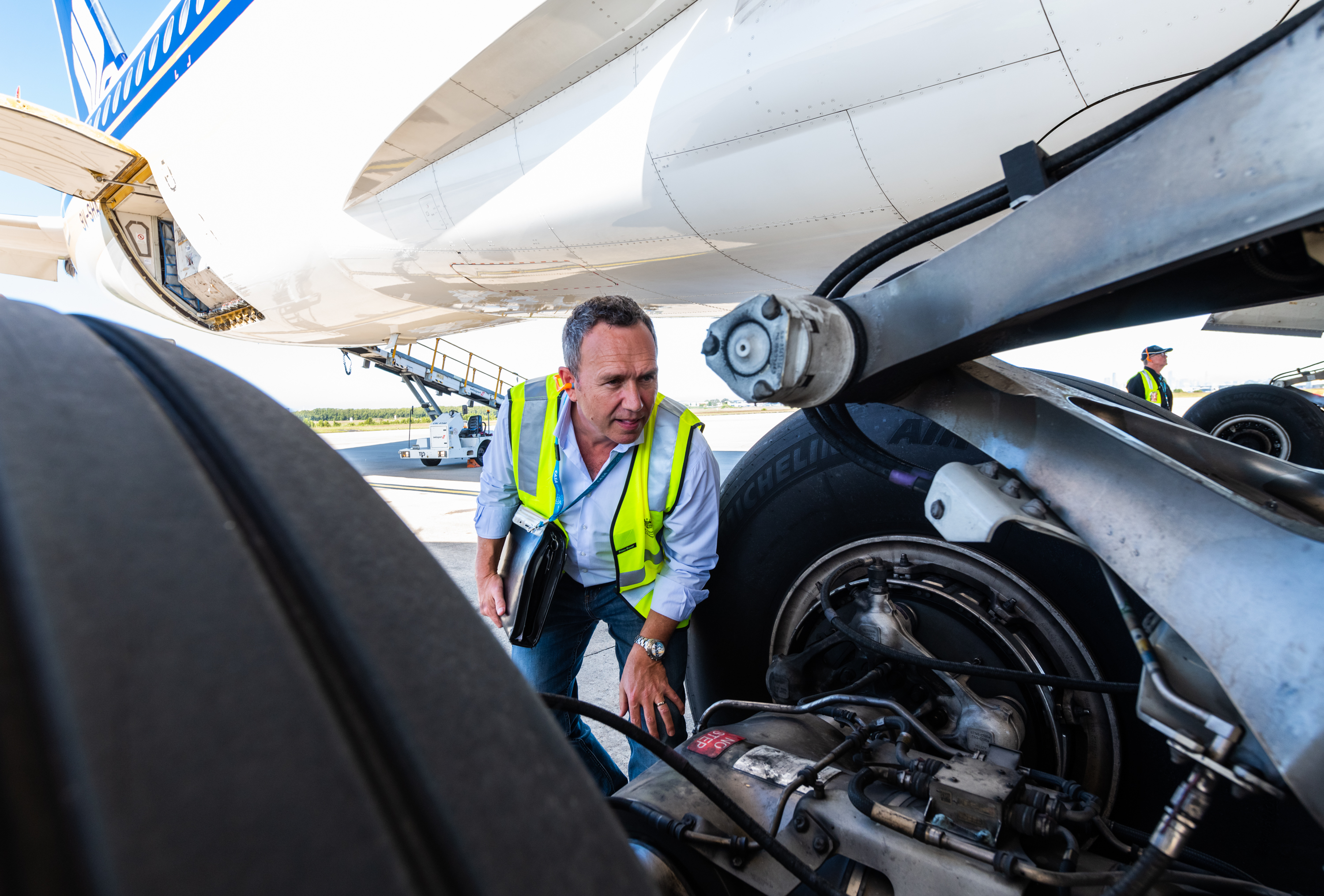A CASA inspector inspecting the landing gear of a plane