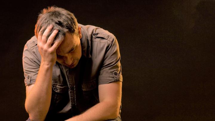Stock image of person holding head looking dejected 