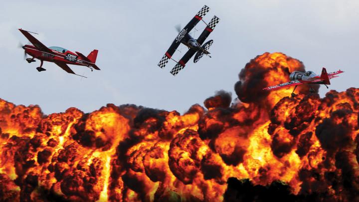 Aircraft flying over fire at an airshow