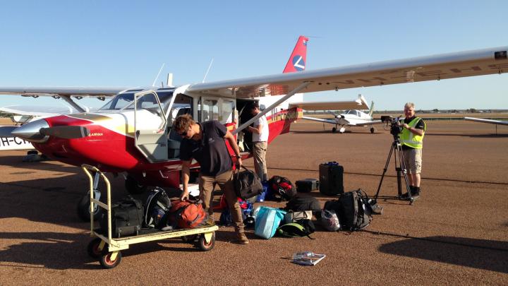 Pilot loading luggage into aircraft