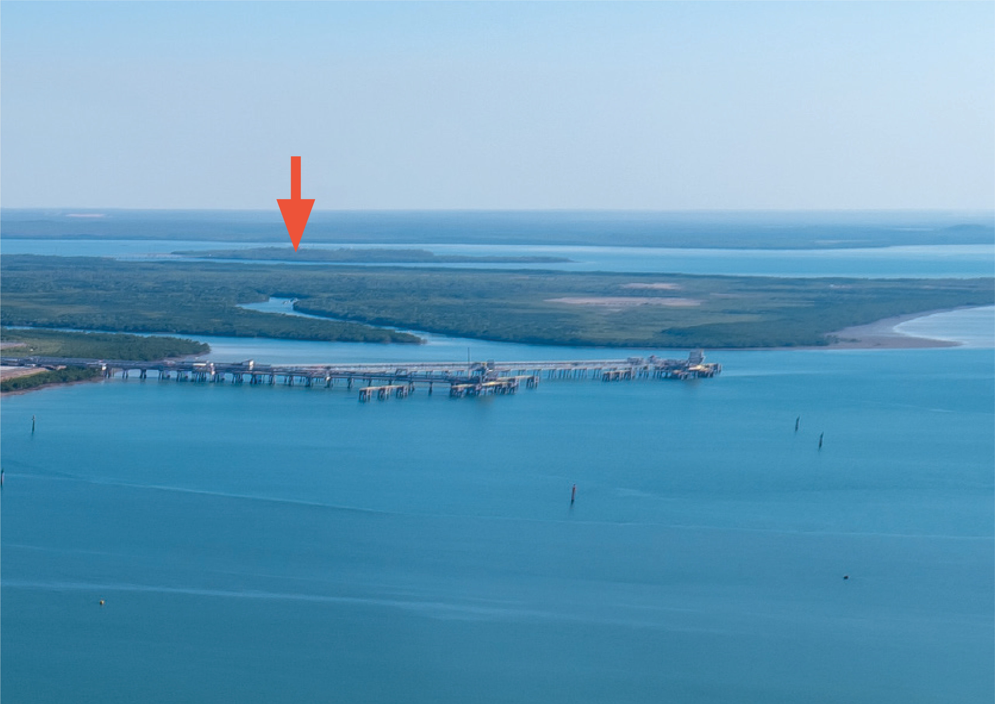 An aerial view of Channel Island, seen from the north, with a red arrow indicating the position of the island