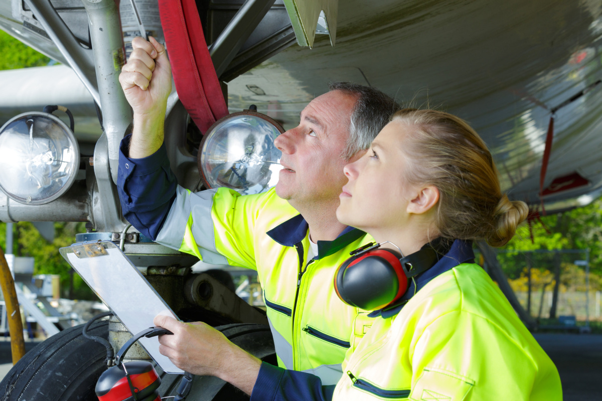 Two maintenance engineers inspecting an aircraft's landing gear