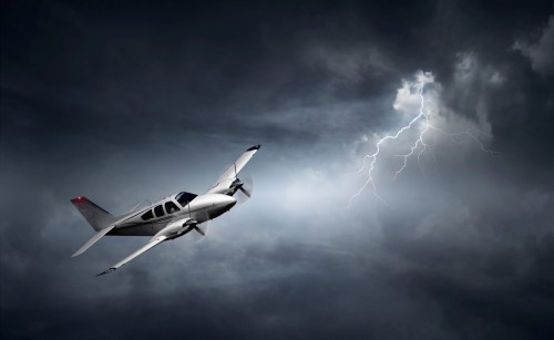 image of a plane flying in a stormy sky