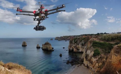 A drone flying with cliffs and the ocean in the background
