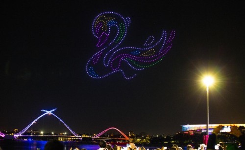Drones flying in the night sky, their lights forming a picture of a swan