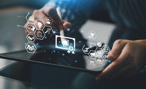 The hands of someone using a tablet computer, while white symbols and blue sparkles hover in the air over it