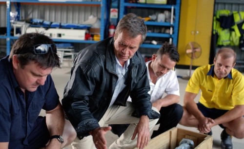Maintenance engineers inspecting a part for an aircraft