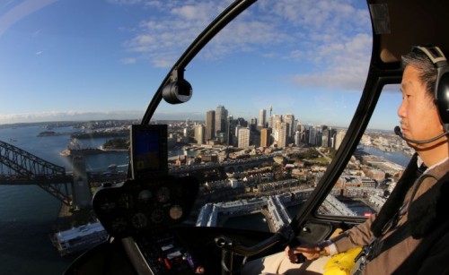 CASA Flight Examiner Patrick Tan flying a Robinson R44 Raven I helicopter over Sydney Harbour