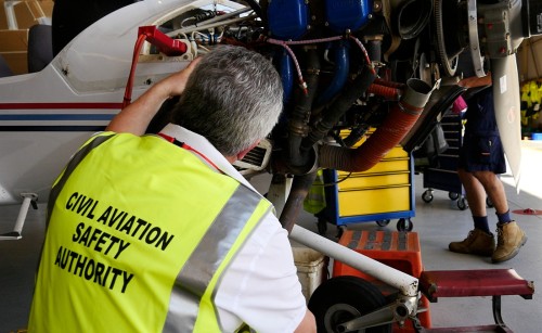 A CASA inspector examining an engine being maintained