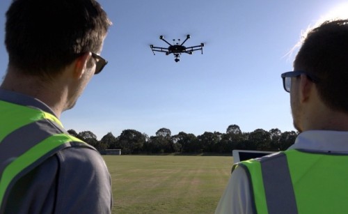A pair of remote pilots flying a drone