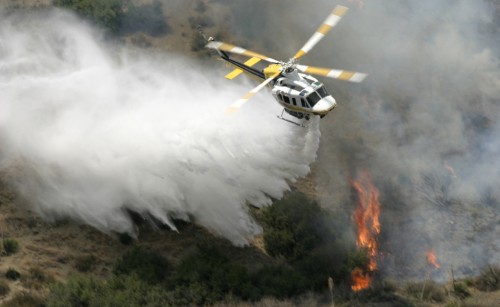 A helicopter dropping water on a bushfire