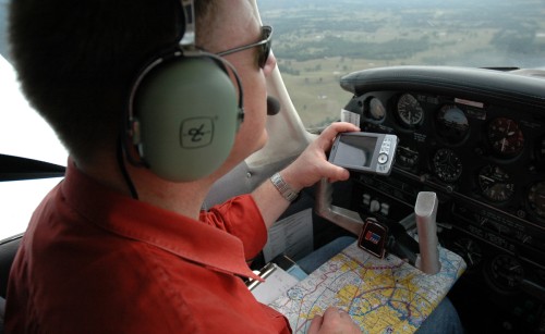 A pilot navigates with his electronic flight bag and a map