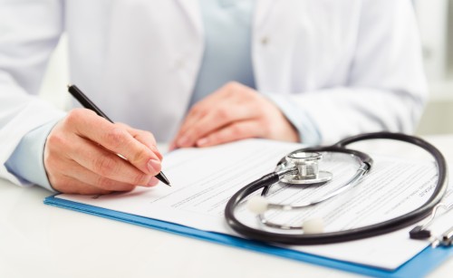 Close up image of a doctor writing