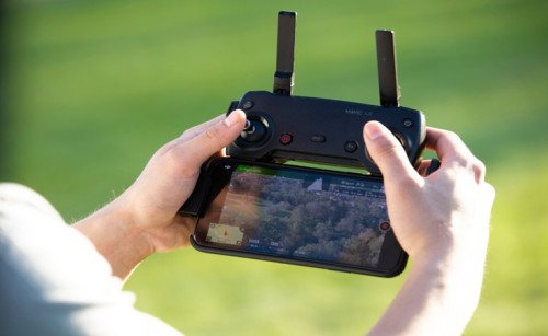 A person's hands holding an RPA remote