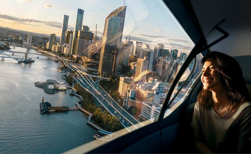 A woman riding in an AAM flying over the Brisbane CBD