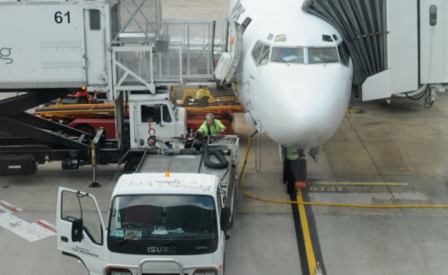 A passenger jet being prepared at an airport terminal