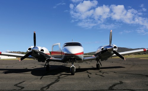 An aeroplane with its door open sitting on the apron of an airport