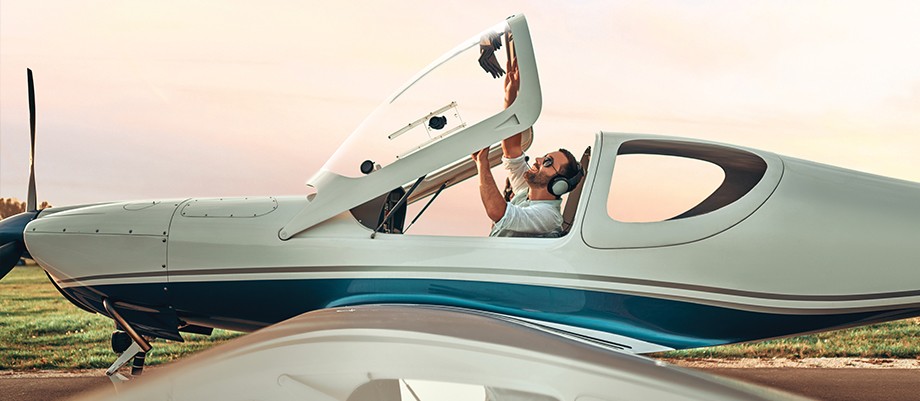 A pilot closing the cockpit hatch of a small aircraft