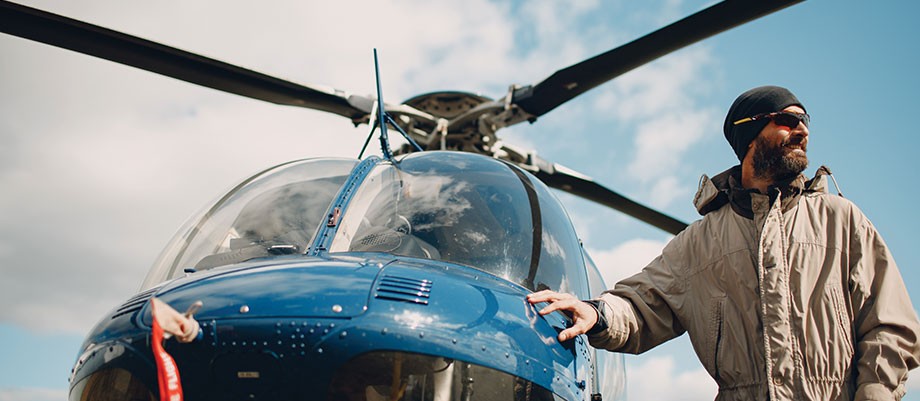 Person standing next to a parked helicopter.