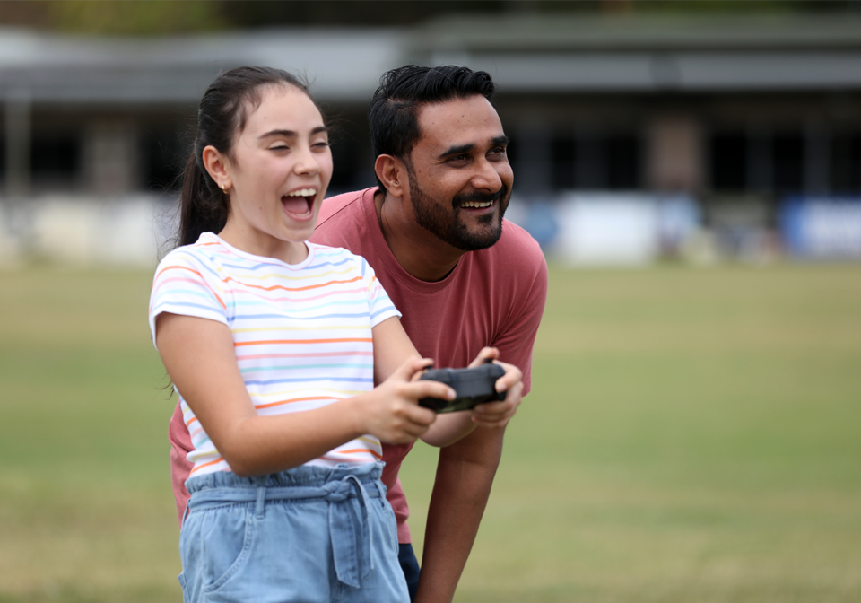 Drone being flown by child and adult.