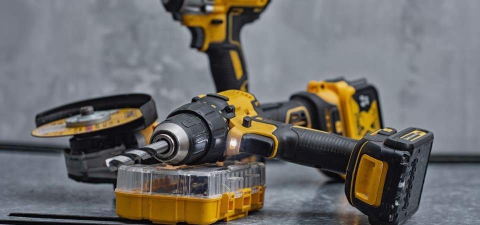 An assortment of battery-powered power tools sitting on a bench