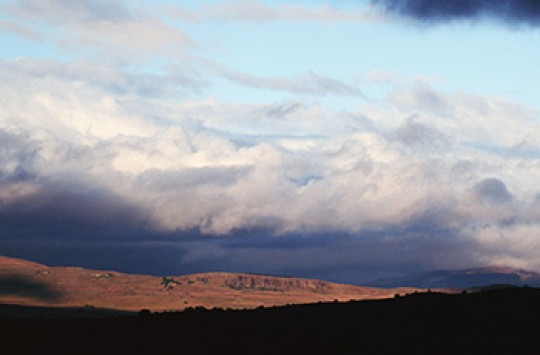 A bank of stormy clouds hanging over dry red land