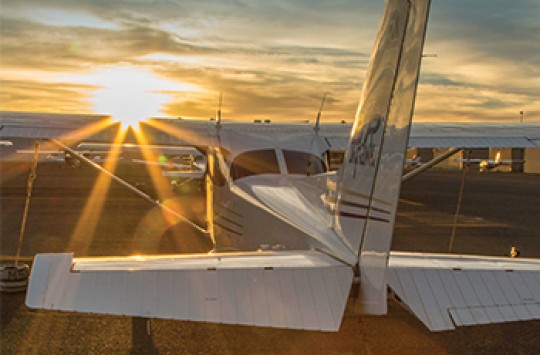 A plane with the sun rising in front of it
