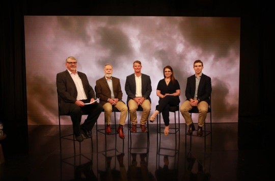 CASA's panel of experts sitting in a row in front of a background depicting a cloudy sky