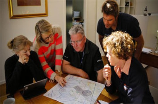 Several pilots gathered around a table looking at a map