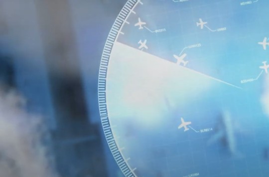An air traffic radar display superimposed over a blurry view of an airplane parked at an airport