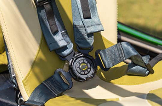 The seat of an airplane with a four-point safety harness installed