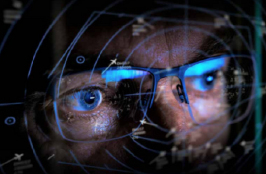 A closeup of the eyes of a man wearing glasses with a flight radar display superimposed on top of it