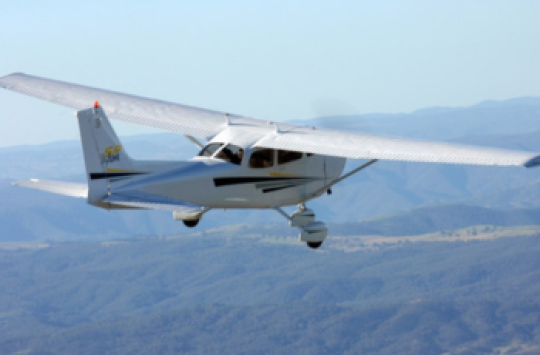 A plane flying above a forest
