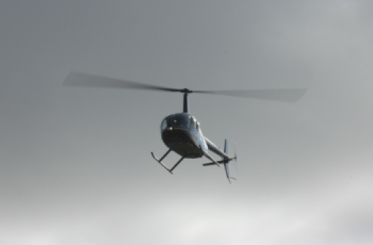 A helicopter flying through a cloudy sky