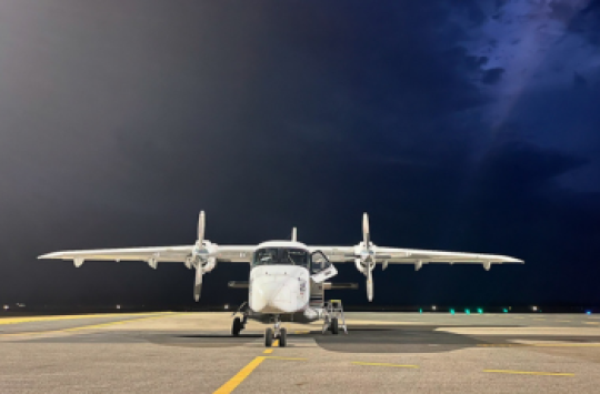 A plane sitting on a taxiway at night