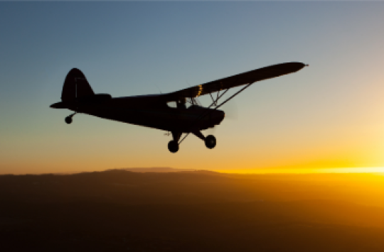 Image of an aircraft flying at sunset