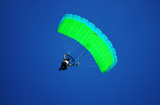 A parachutist gliding through the air