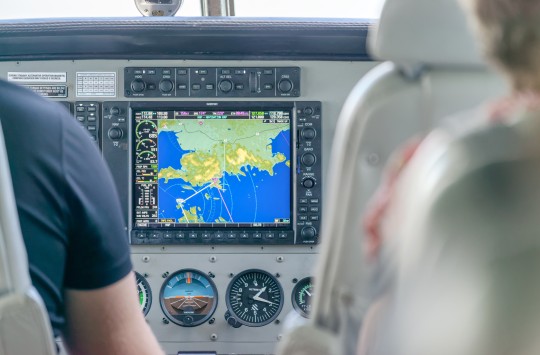 The cockpit of an aircraft, with a display showing navigational information prominent