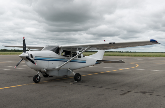 An aeroplane sits on a taxiway under a cloudy sky