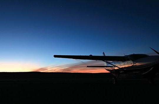 An aeroplane silhouetted against the dawn sky