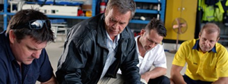 A safety manager holds a meeting in a hangar