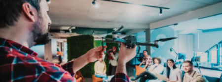 A person in an office holding a drone