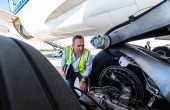 A CASA inspector inspecting the landing gear of a plane