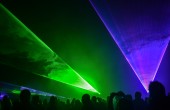 A laser display with people dancing in the foreground