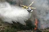 A helicopter dropping water on a bushfire