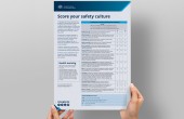 A person holding a ‘Score your safety culture checklist’ poster. The poster includes a scoring table for assessing organisational safety culture, a health warning box, explanatory text and CASA contact details at the bottom.